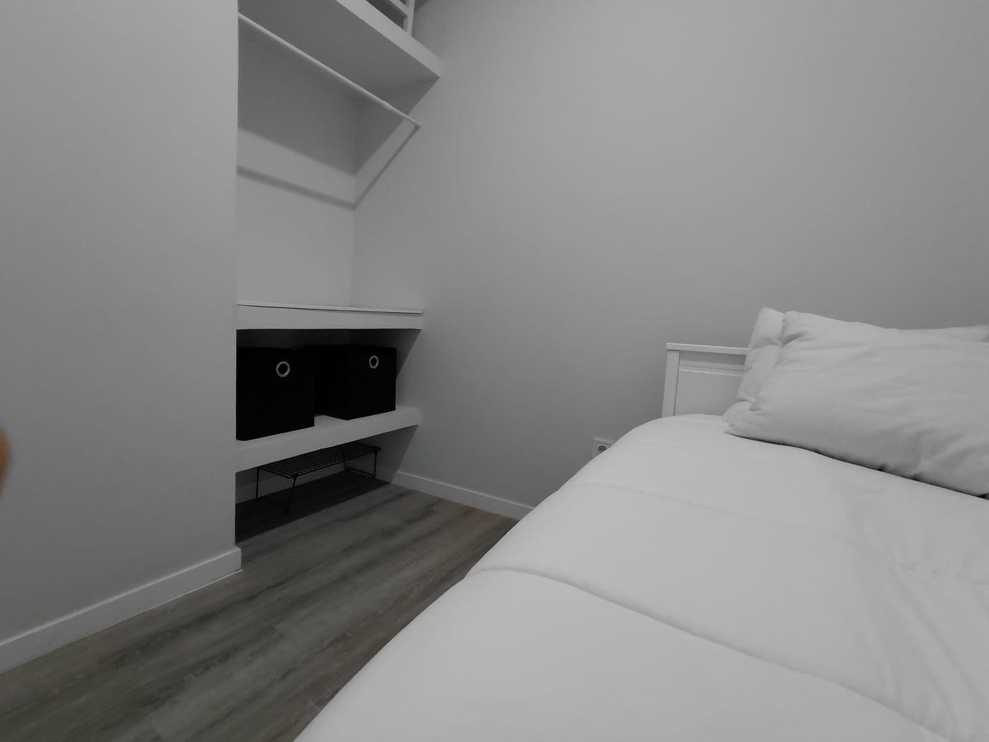 Second bedroom with built-in shelving and organized box storage, ideal as a +1 or workspace