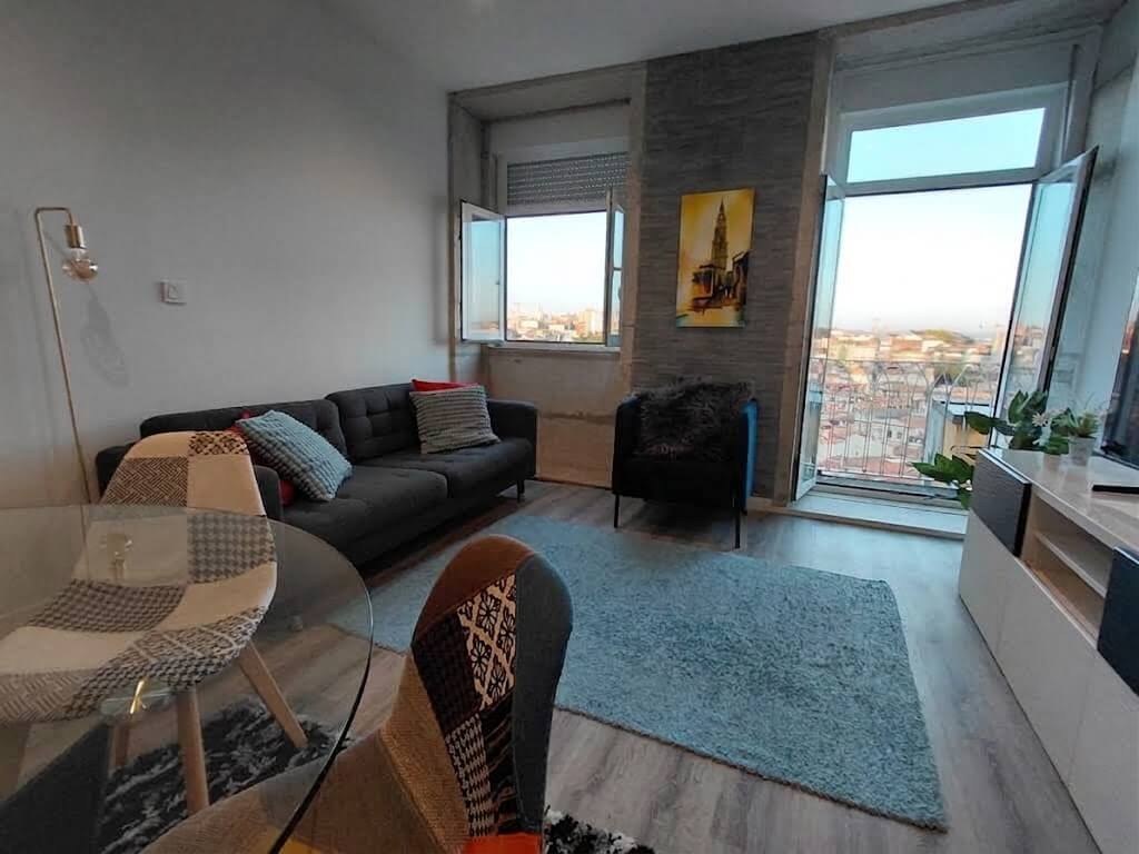 Living room lounge area, sofa and rug by the windows with a view over the city