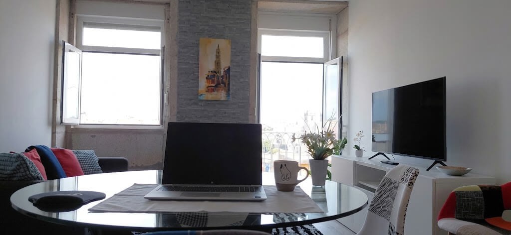 Living room with TV, Clérigos Tower painting and a city view from the dining table, Porto Skyline Residence