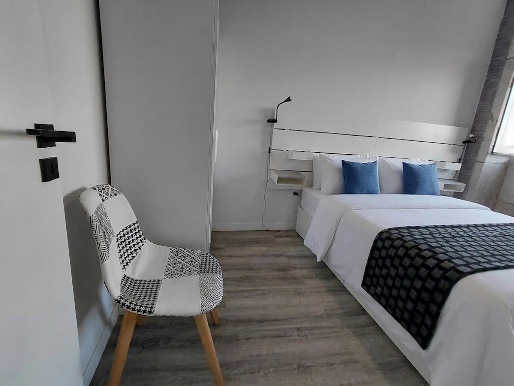 Main bedroom, reading corner with a patterned chair and white slatted headboard, Porto Skyline Residence